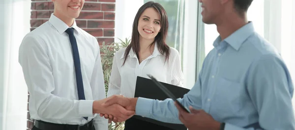 Handdruk van jonge businesspartners in het kantoor — Stockfoto