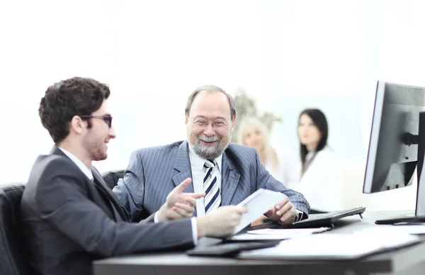 Twee zakenlieden bespreken werk kwesties achter hun bureau — Stockfoto