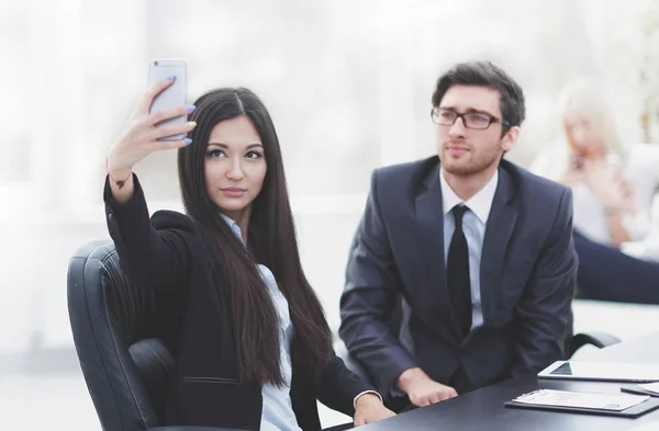 Jóvenes empleados se están tomando selfies en su escritorio . — Foto de Stock