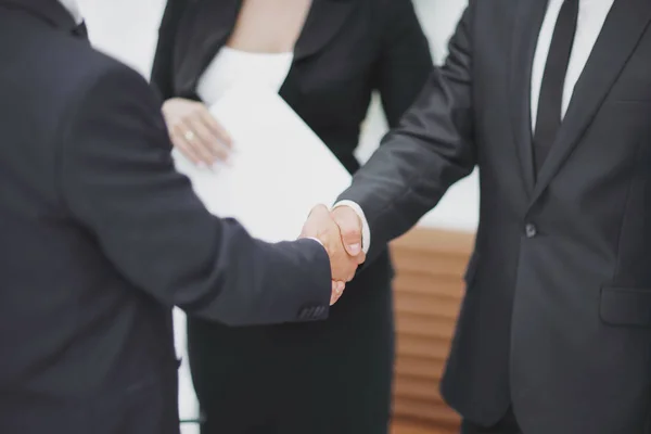 Cerrar up.handshake socios comerciales en el fondo de la oficina — Foto de Stock