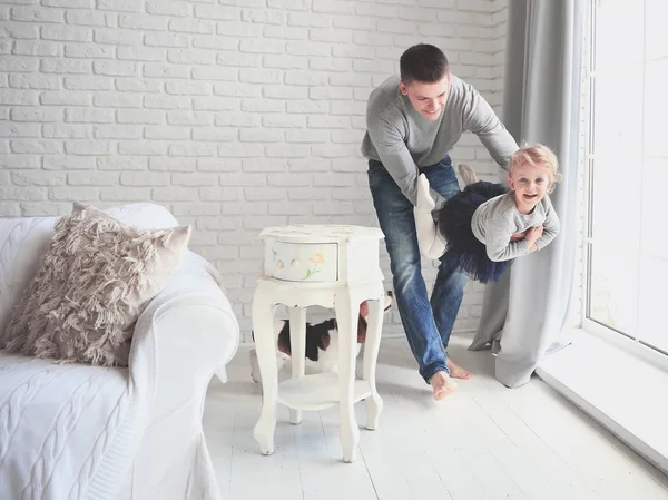 Glücklicher Vater beim Spielen mit seiner kleinen Tochter im hellen Wohnzimmer — Stockfoto