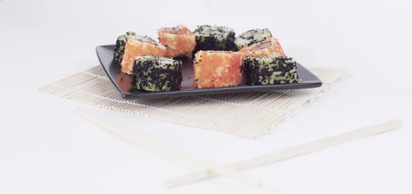 Különböző típusú maki sushi egy fekete tányéron — Stock Fotó