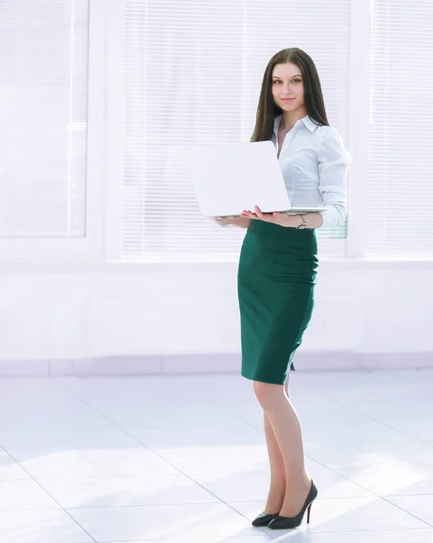 Assistente femminile con un computer portatile aperto mentre in piedi in ufficio — Foto Stock