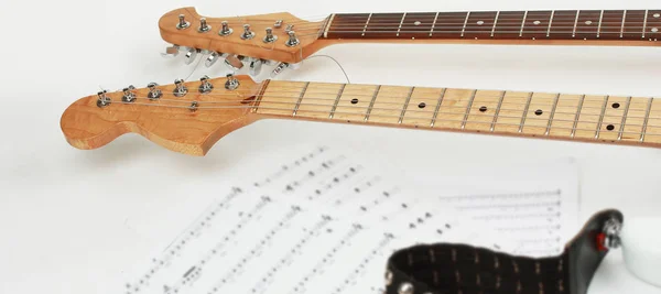 Primer plano .sheet música y guitarra sobre un fondo blanco . — Foto de Stock
