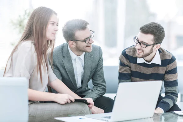 Erfolgreiches Business-Team mit Laptop am Arbeitsplatz diskutiert Arbeitsfragen. — Stockfoto