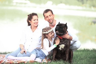 Güneşli bir yaz gününde piknikte köpekli mutlu bir aile. pregn