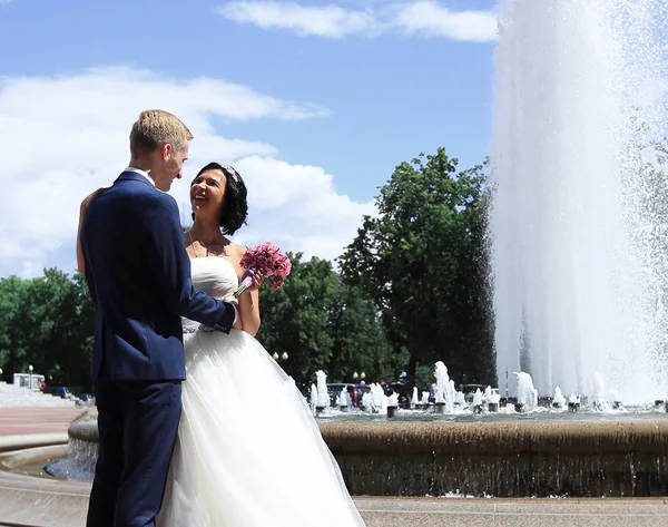 Beau couple souriant debout près de la fontaine — Photo