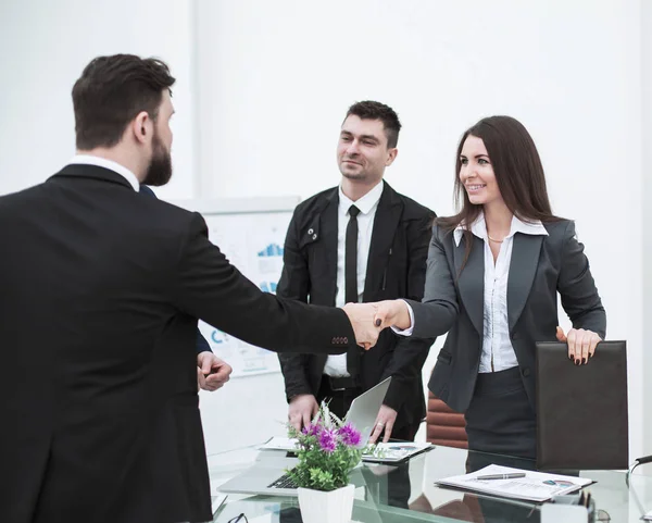 Handshake obchodními partnery na schůzce poblíž plochy v moderní kanceláři — Stock fotografie