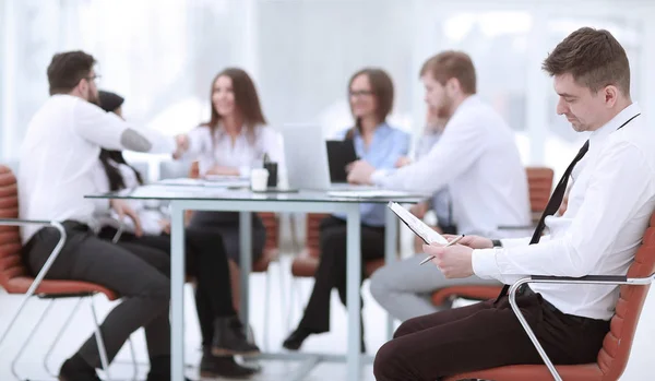 Młody biznesmen czytanie dokumentu, siedząc w swojej koncepcji office.business — Zdjęcie stockowe