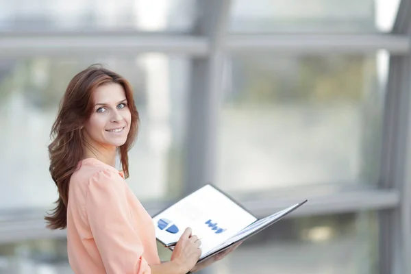 Rear view.a young business woman holds a folder with financial documents — Stock Photo, Image