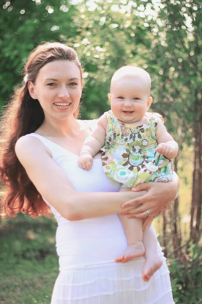 Anne ve mutlu kızı parkta bir yürüyüş üzerinde gülümseyen