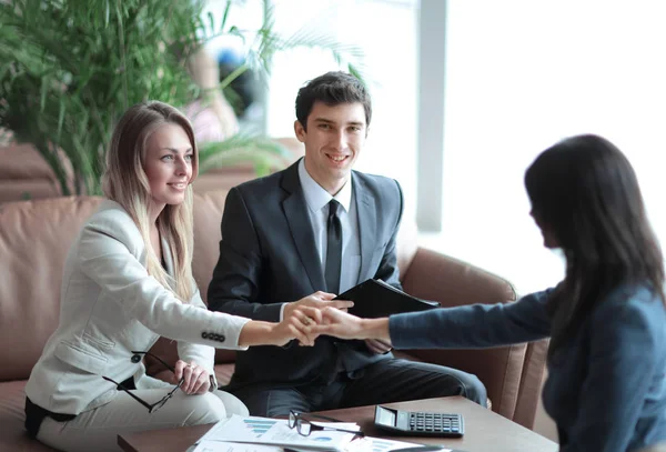 Zwei Geschäftsfrauen halten sich an den Händen, sitzen am Schreibtisch — Stockfoto