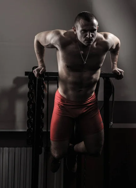 Culturista en el gimnasio realiza ejercicios para el culturismo . —  Fotos de Stock