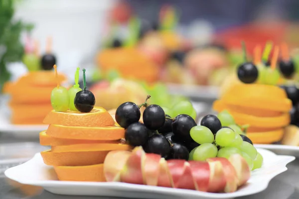 Close up.apples, oranges and grapes on a plate — Stock Photo, Image