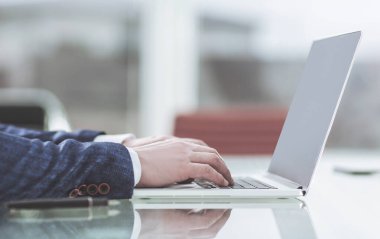 İşyerinde dizüstü bilgisayarda çalışan başarılı bir iş adamı.