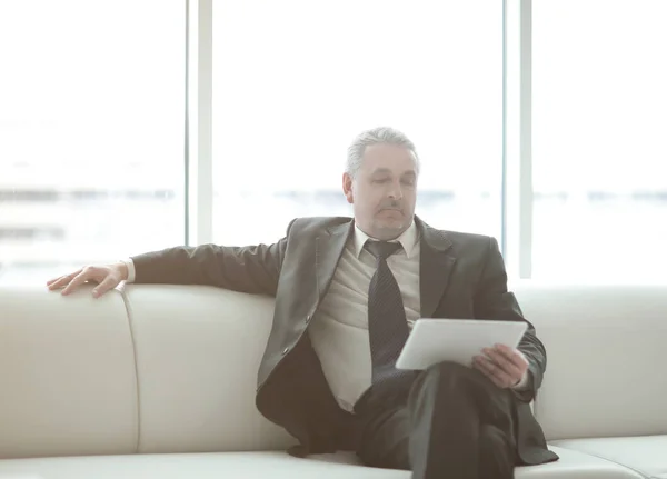 Hombre de negocios serio leyendo texto en una tableta digital — Foto de Stock