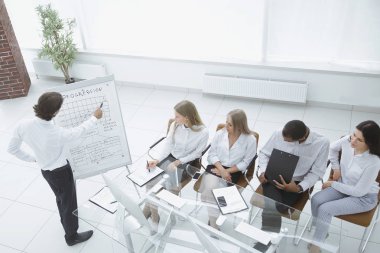 İş adamı yeni pazarlama planını iş arkadaşlarına sunuyor..