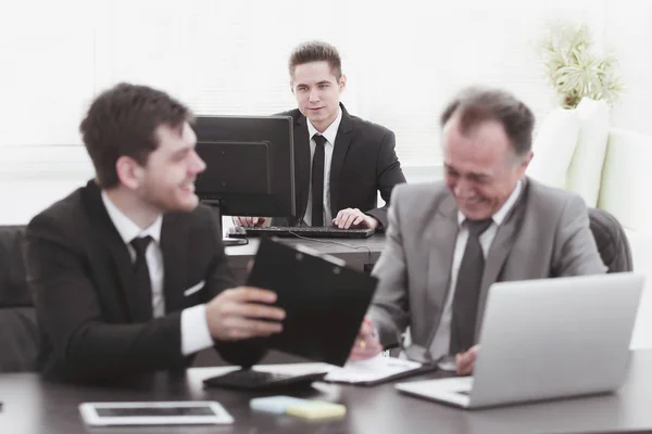 boss and employee discussing the document sitting at the Desk in the office.