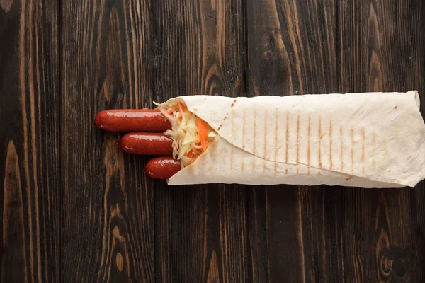 sausages in pita bread on wooden background.photo with copy spac