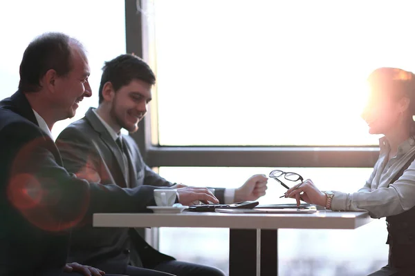 Equipo de negocios está contando los beneficios de usar la calculadora — Foto de Stock