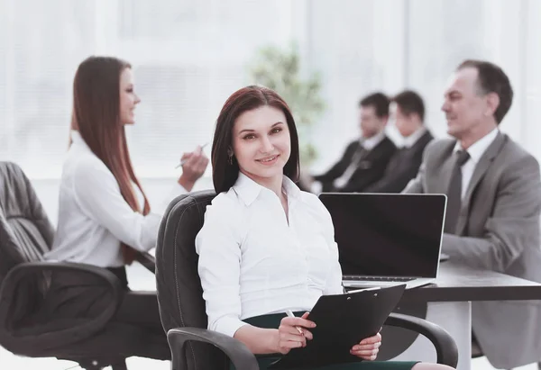 Joven mujer de negocios con portapapeles en el fondo del equipo de negocios — Foto de Stock