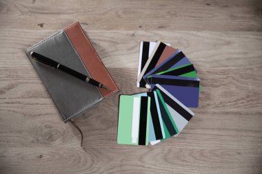 kredi kartları, Not defteri ve kalem ahşap arka plan üzerinde