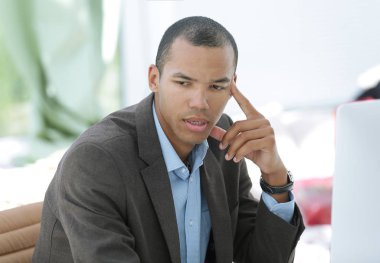 bir masanın arkasında oturan dalgın işadamı portresi.