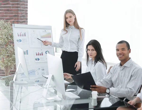 Successful employee is standing by flipchart in office — Stock Photo, Image