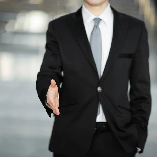 handsome businessman holding out hand for a handshake.the concept of partnership