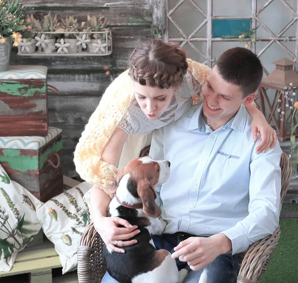 young couple with pet sitting on a chair