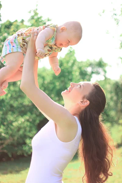 Gelukkig mam speelt met haar dochtertje in de zomer park — Stockfoto