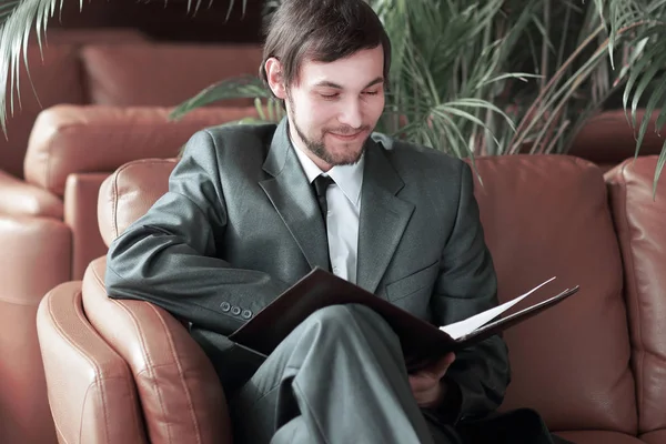 Close up.smiling handsome businessman reading documents — Stock Photo, Image