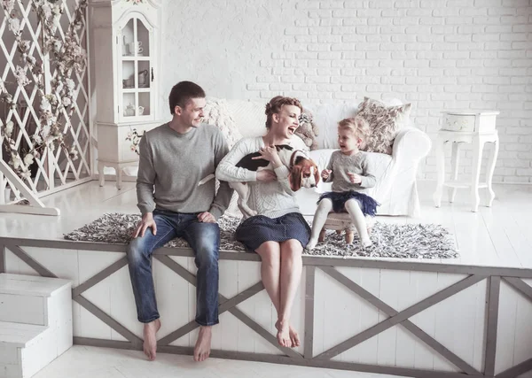 Mutlu bir ailenin ve evcil hayvanlarının rahat bir oturma odasında portresi.