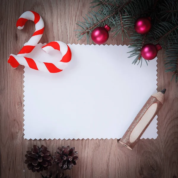 Tarjeta de Navidad en blanco, conos de pino y lápiz sobre fondo de madera —  Fotos de Stock