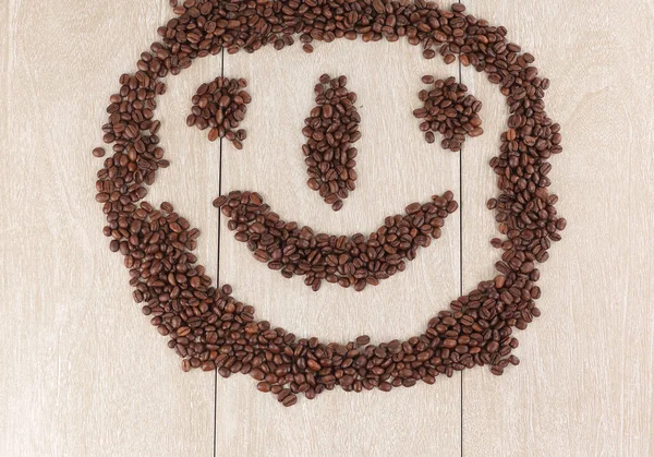 Zabawna buzia ziaren kawy czarny na podłoże drewniane — Zdjęcie stockowe