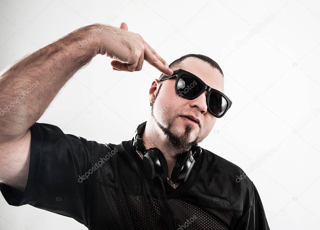 portrait of a badass rapper in sunglasses with headphones on a w