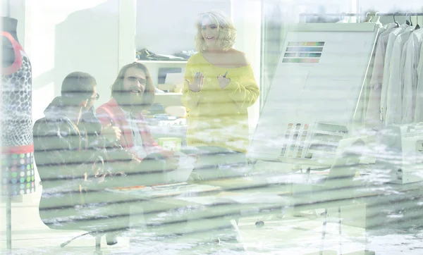 View through the blinds. a group of fashion designers in a modern Studio