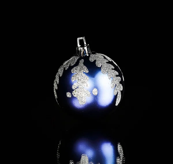 Bola de Natal azul brilhante em um fundo preto . — Fotografia de Stock