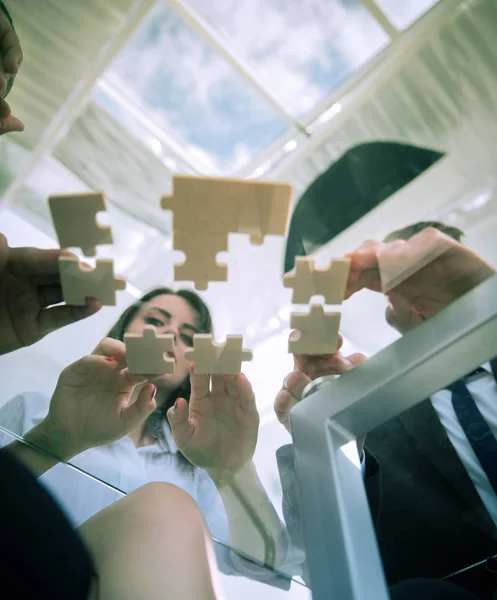 Underifrån. Business-team fällbara pusselbitar. . — Stockfoto