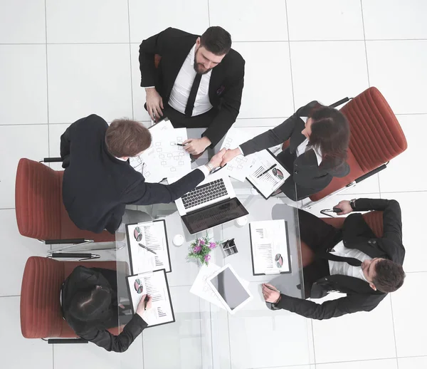 Top view.handshake parceiros de negócios depois de discutir os termos financeiros do contrato — Fotografia de Stock