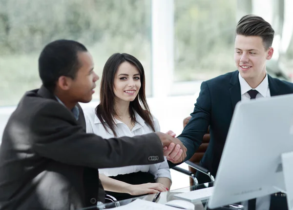 Stretta di mano partner commerciali internazionali su una scrivania — Foto Stock