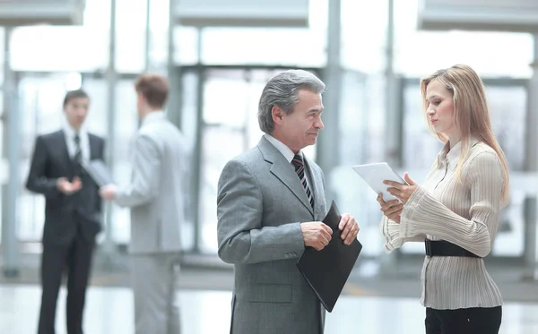 Geschäftsmann und Assistent diskutieren über Arbeitsthemen. Foto auf verschwommenem Bürohintergrund — Stockfoto