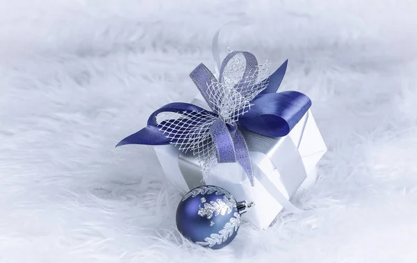 Kerstcadeau en blauwe kerstballen op een feestelijke witte rug — Stockfoto