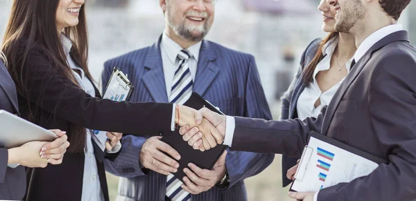 Handshake finanční partnery a zástupci firmy na pozadí úřadu — Stock fotografie