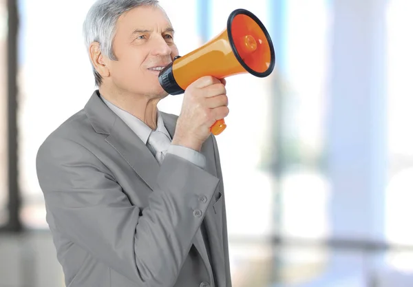 Mature businessman with megaphone.isolated on a white background. — Stock Photo, Image