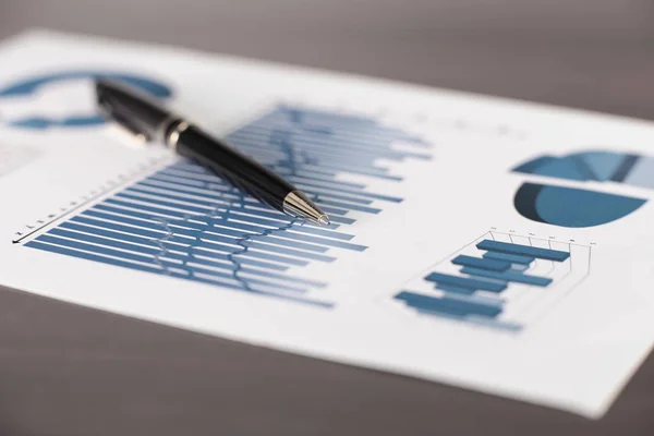 Geschäftshintergrund.Ein Stift und ein Blatt mit einem Finanzbericht auf dem Tisch — Stockfoto