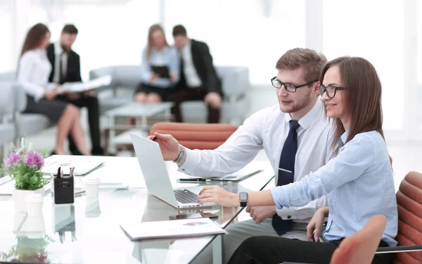 Unga företag man arbetar tillsammans med hennes kollega på laptop i office. — Stockfoto