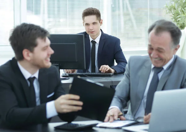 boss and employee discussing the document sitting at the Desk in the office.