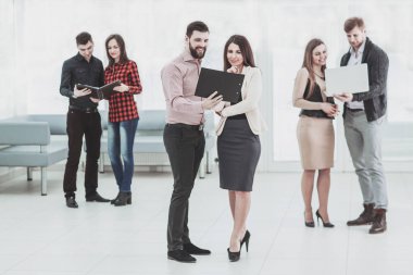 Toplantıdan önce Office lobide duran belgeleri tartışırken iş takım