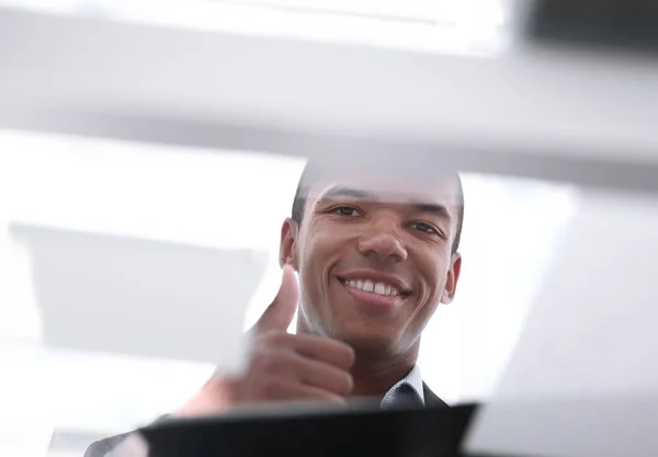 bottom view. image of young businessman showing thumb up.